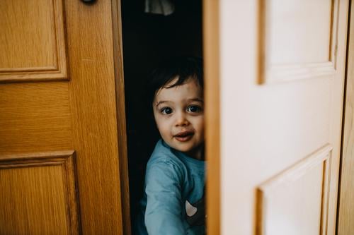 Kind versteckt sich auf dem Kleiderschrank Kindheit 1-3 Jahre Kaukasier authentisch Lifestyle Farbfoto Leben Kindheitserinnerung Mensch Freude Tag