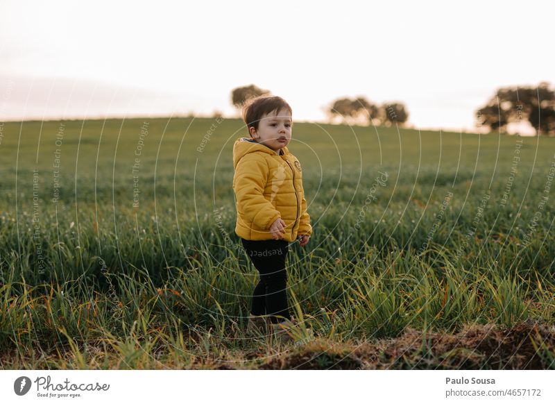 Kind mit gelber Jacke auf einer Wiese Kindheit Kaukasier Lifestyle authentisch Freude Kindheitserinnerung Farbfoto mehrfarbig Gefühle Außenaufnahme Mensch