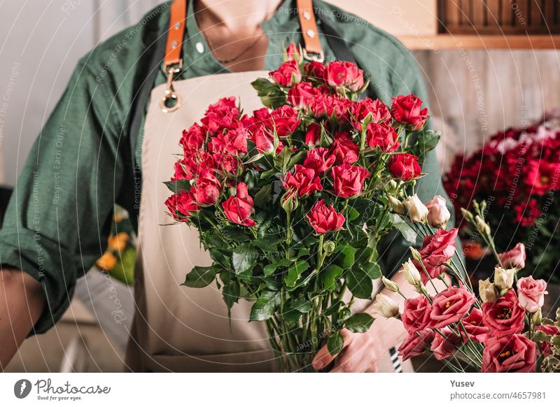 Floristen machen Geschenksträuße. Anmutige Frauenhände machen einen schönen Blumenstrauß. Florist Arbeitsplatz. Kleines Geschäft Konzept. Blumen und Zubehör. Hände Stockfoto