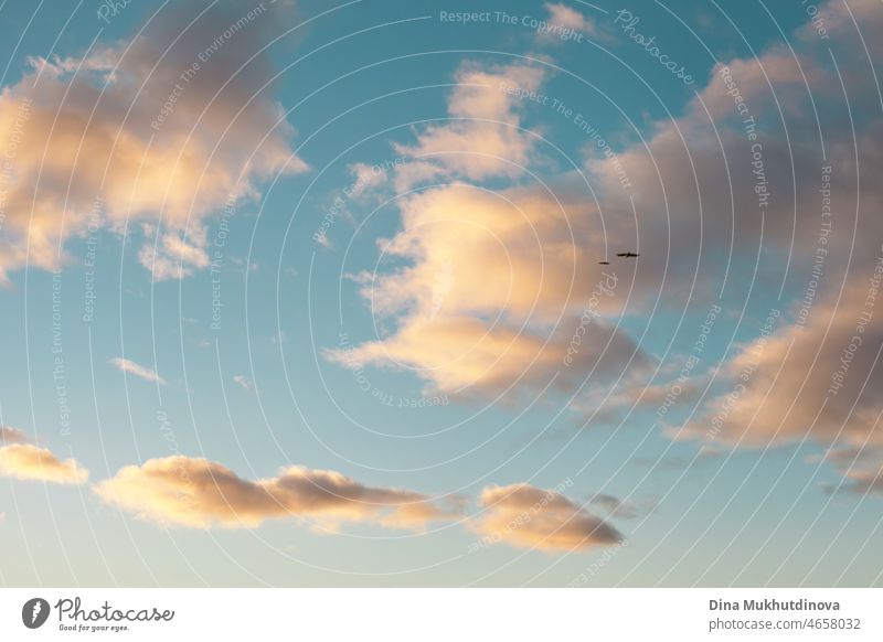 Blauer Himmel und Wolken als friedliche idyllische Wolkenlandschaft mit zwei fernen Vögeln, die hoch fliegen. Freiheit Konzept. Schöne blauen Himmel Hintergründe mit Wolken mit Sonnenuntergang Licht hervorgehoben.