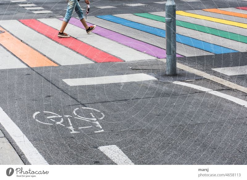 Mit flotten Schritten über den Regenbogen-Zebrastreifen. regenbogenfarben gestreift Straße Radweg Toleranz Verkehrswege Fußgänger Asphalt Überqueren
