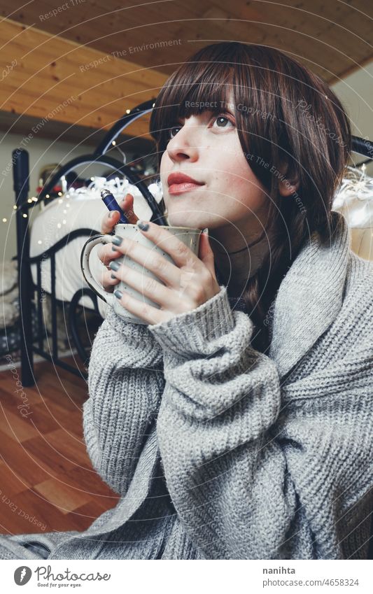 Junge und verträumte Frau genießt eine Tasse Kaffee heimwärts warm Tee Winter Herbst Stimmung Porträt Komfort ruhig Ruhe Leben Lifestyle bequem niedlich brünett