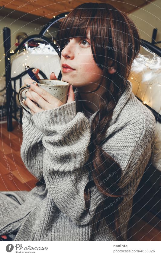 Junge und verträumte Frau genießt eine Tasse Kaffee heimwärts warm Tee Winter Herbst Stimmung Porträt Komfort ruhig Ruhe Leben Lifestyle bequem niedlich brünett