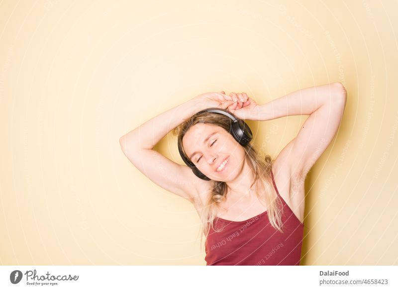glückliche Frau beim Musikhören Glück deadphone gelber Hintergrund