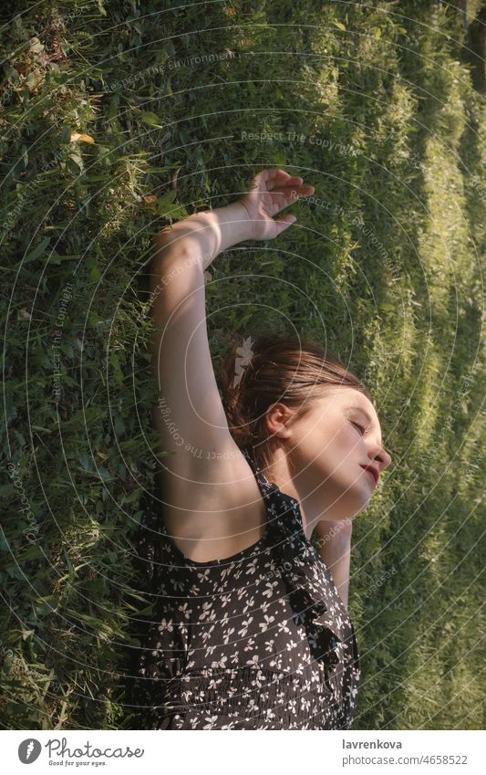 Junge Frau in schwarzem Kleid auf grünem Gras liegend Kaukasier Porträt Wiese Natur oben Erwachsener Tagträumen Garten Mädchen Hände Glück Freizeit Lifestyle