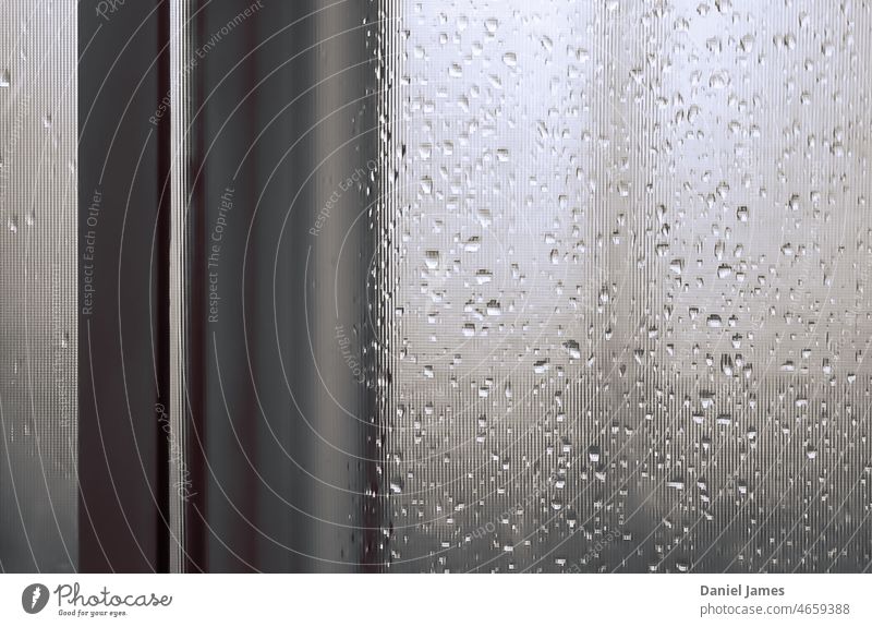 Ein Fenster an einem regnerischen Tag Regen Wassertropfen Fensterscheibe Wetter nass Glas grau Traurigkeit trist abstrakt schwarz auf weiß Ausschau haltend