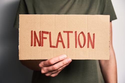 Welt Inflation Konzept. Frau hält Blatt mit Wort Inflation Krise Finanzen wirtschaftlich Risiko Verbraucher hoch Währung uns Europa Business Dollar Erhöhung
