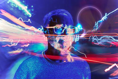 Ein Mann im Metaversum, umgeben von Lichtern und futuristischen Effekten, die eine künstlerische Darstellung der Verschmelzung von virtueller Realität und Wirklichkeit darstellen