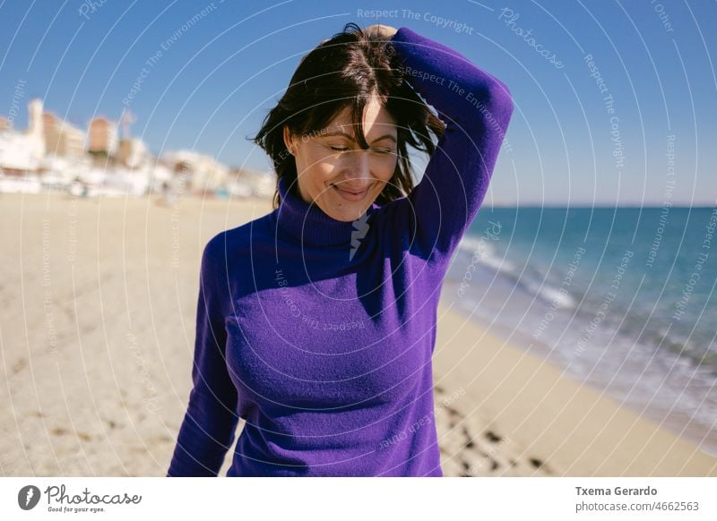 Schöne glückliche reife Frau, die einen sonnigen Wintertag am Strand genießt 45-50 Jahre MEER Achtsamkeit Freiheit Emotion genießend positiv Erholung Stehen