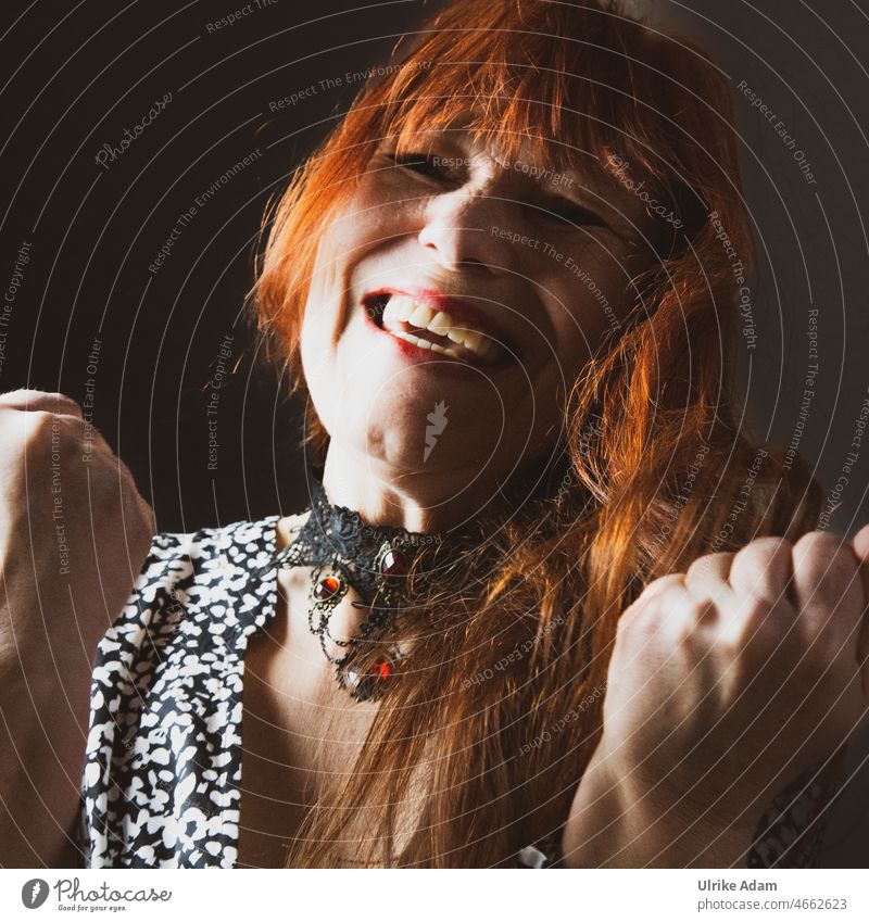 1000|Frau freut sich über den Sieg Freude Glorreich Daumen hoch Lachen Lebenslust Rote Haare Glück Porträt Fröhlichkeit rote Haare lachen Gesicht Lächeln