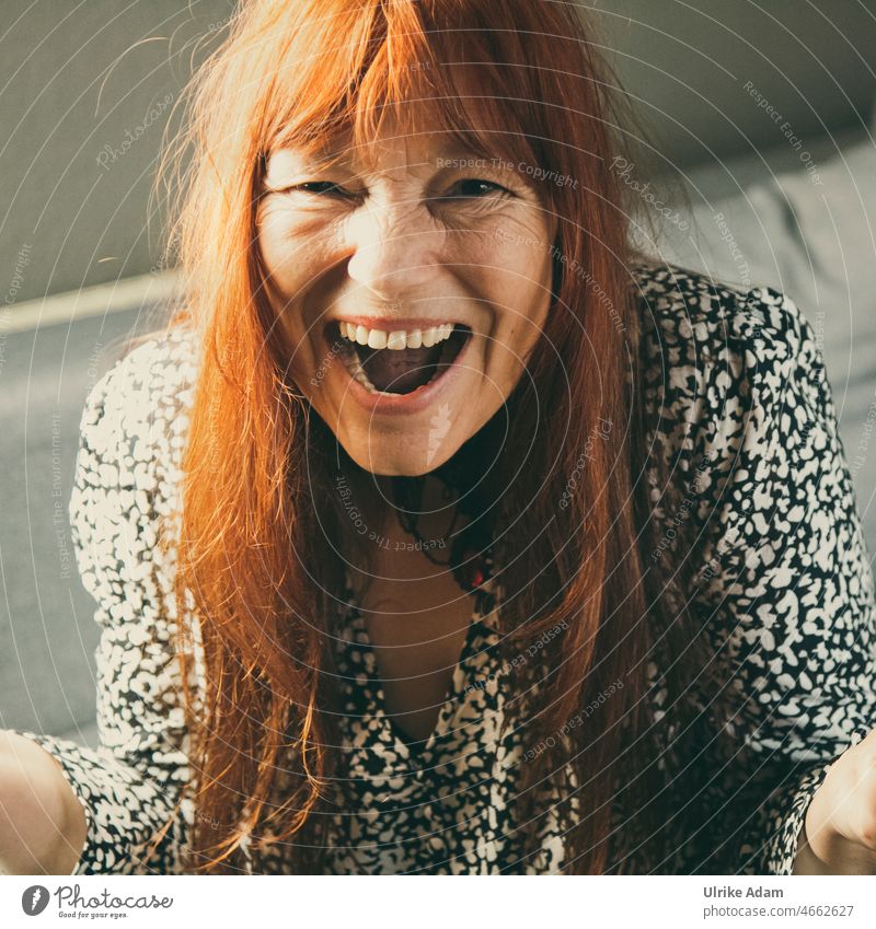 Freude - Frau mit roten langen Haaren lacht mit offenen Mund in die Kamera langhaarig glücklich Spaß haben Gesicht Porträt Lächeln Lebensfreude Glück