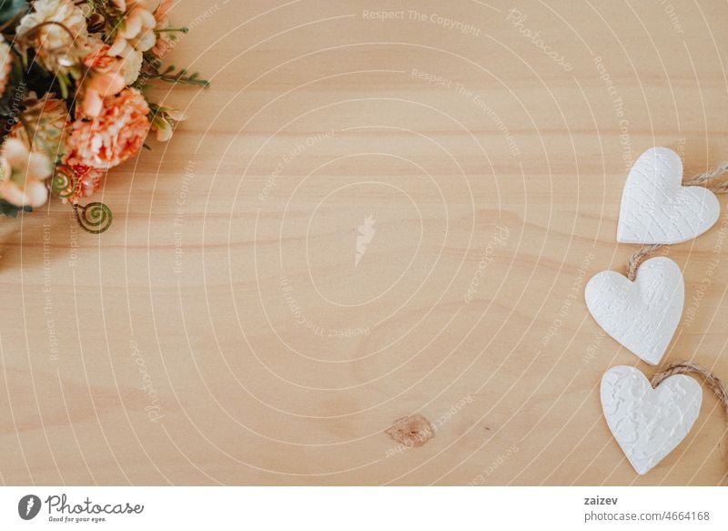 Holztisch mit einer Blume und einem Herz weiß Tisch Textfreiraum Hintergrund geblümt Blumen Blumenstrauß Haufen niemand Arbeitsbereich Schreibtisch hölzern