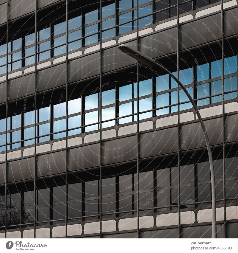 Moderne Fassade mit Beton und Glas, gesiegelter Himmel und Straßenlaterne urban Laterne Spiegelung blau Stadt Architektur Gebäude modern Bürogebäude Business