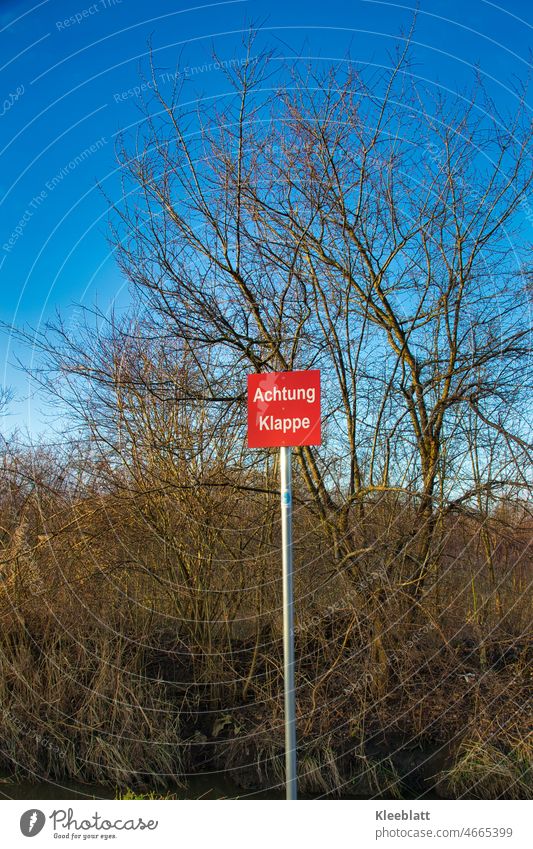 Rotes Warnschild mit Aufschrift - Achtung Klappe - in freier Natur an einem versteckten Bachlauf Schilder & Markierungen Warnhinweis Hinweisschild Vorsicht