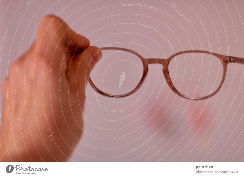 Eine Hand hält eine Brille in rosa. Durchsicht, Durchblick. Sehhilfe sehhilfe durchblick durchsicht Blick Sehvermögen Brillenträger Brillengestell halten