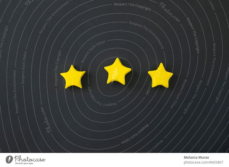 Drei goldene Sterne auf schwarzem Hintergrund. Goldene Sternform. Konzept der Spitzenklasse, beste Qualität Produkt-Symbol. Zeichen der Bewertung, Feedback von Kunden.