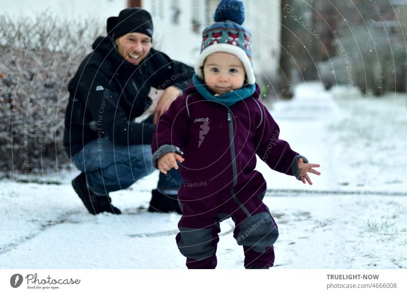 Ein kleiner erst 1 Jahr alter Junge entdeckt das alleine Laufen und den ersten Schnee seines Lebens während sein Papa im Hintergrund aufpasst und sich freut