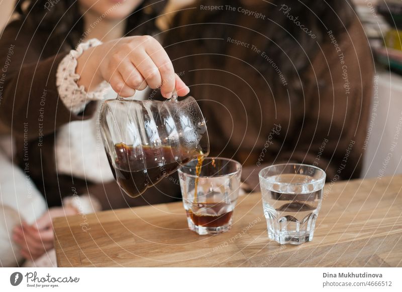 Unbekannte Frauen gießen Filterkaffee in einem Café ein. Mädchen treffen sich im Café, um Kaffee zu trinken und zu reden. Millennial Lebensstil. Restaurant Stil