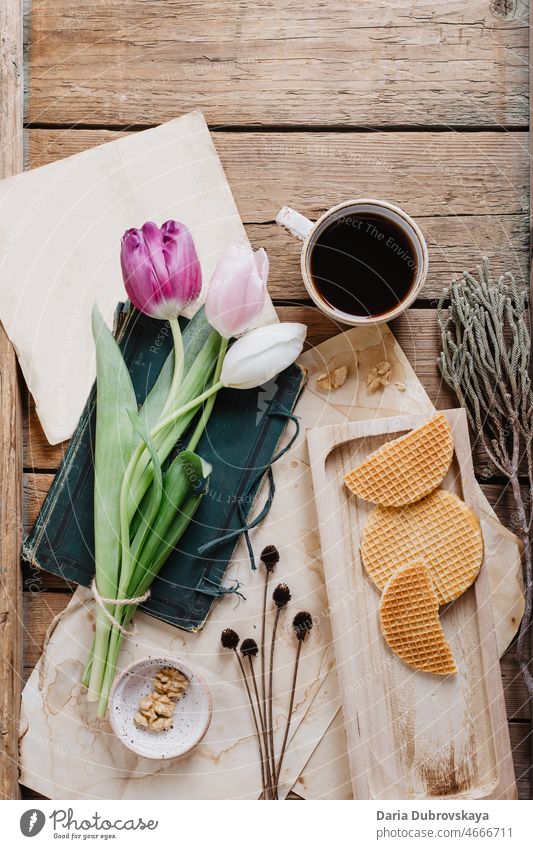 Kaffee, Waffeln und Tulpen auf einem Holztisch Blume geschmackvoll Ansicht Café Espresso Aroma Nahaufnahme Konzept Frühling frisch Blumenstrauß Frühstück heiß