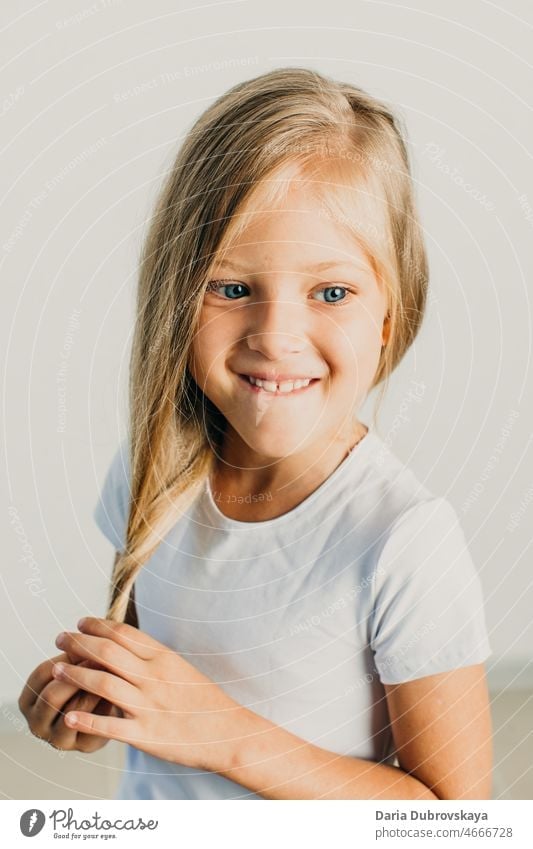 Süßes Mädchen 7 Jahre alt blond mit blauen Augen Behaarung spielerisch Hand Finger lieblich hübsch Ausdruck Porträt zeigend Kaukasier Glück schön weiß Frau