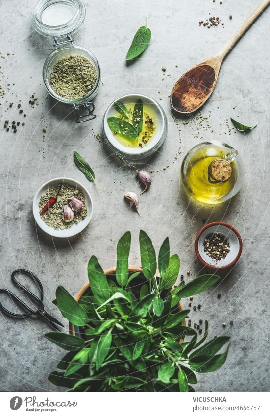 Gesunde Kochzutaten: Kräutersalz, Olivenöl, Salbei, Pfeffer, Knoblauch, Chili und Küchenutensilien Gesundheit Essen zubereiten Zutaten Paprika Peperoni