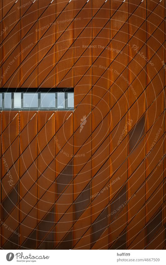 Fensterreihe in einer rostigen Stahlfassade Abstr Architektur Rost rostiges Metall Fassadenverkleidung Rautenmuster Moderne Architektur modern Gebäude Muster