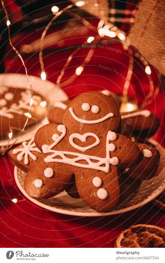 Fröhlicher Pfefferkuchenmann süß Glück Süßigkeiten Lebkuchen Lebkuchenmann Weihnachten weihnachtsplätzchen rot Vor dunklem Hintergrund backen Bäcker Gesicht