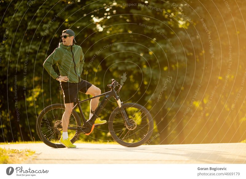Junger Mann fährt E-Bike in der Natur aktiv Batterie Fahrrad Biker Radfahren schwarz Zyklus Radfahrer ebike Öko ökologisch Ökologie elektrisch Elektro Energie
