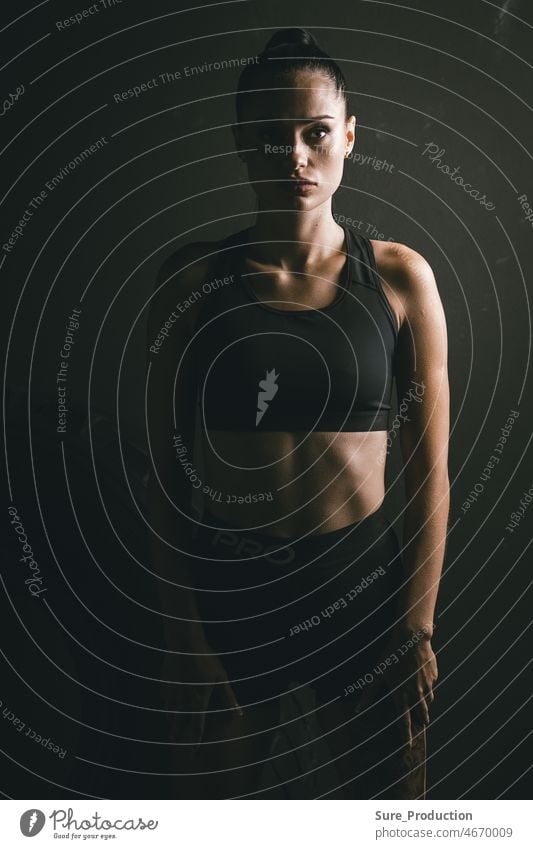 Idee für ein Plakat. Porträt einer jungen Frau in einem trendigen Trainingsanzug. Sportliche Themen Kämpfer durch menschlich dunkel Käfig hinten bricht
