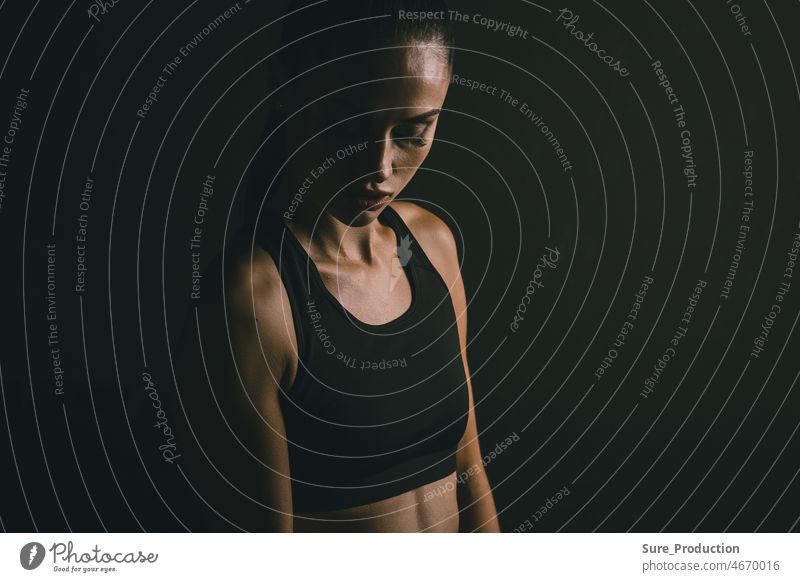 Porträt einer jungen attraktiven Sportlerin auf schwarzem Hintergrund während des Trainings. Konzept für sportliche Motivation Wut Athlet schön Körper