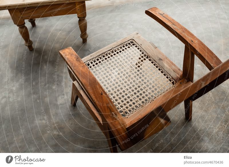 Sessel aus Holz mit Wiener Geflecht auf Beton Stuhl Sitzgelegenheit Material alt vintage Kolonialstil Möbel Balkon leer terrassenmöbel Terrasse Gartenmöbel
