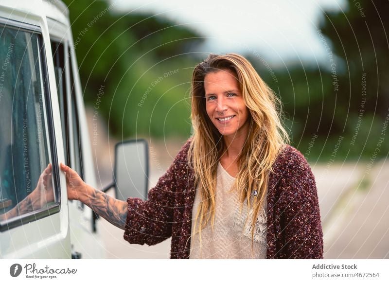 Lächelnde Frau in der Nähe des Wohnmobils während einer Autoreise Reisender Kleintransporter Fernweh erkunden Ausflug Wohnwagen reisen PKW rv Tür Verkehr