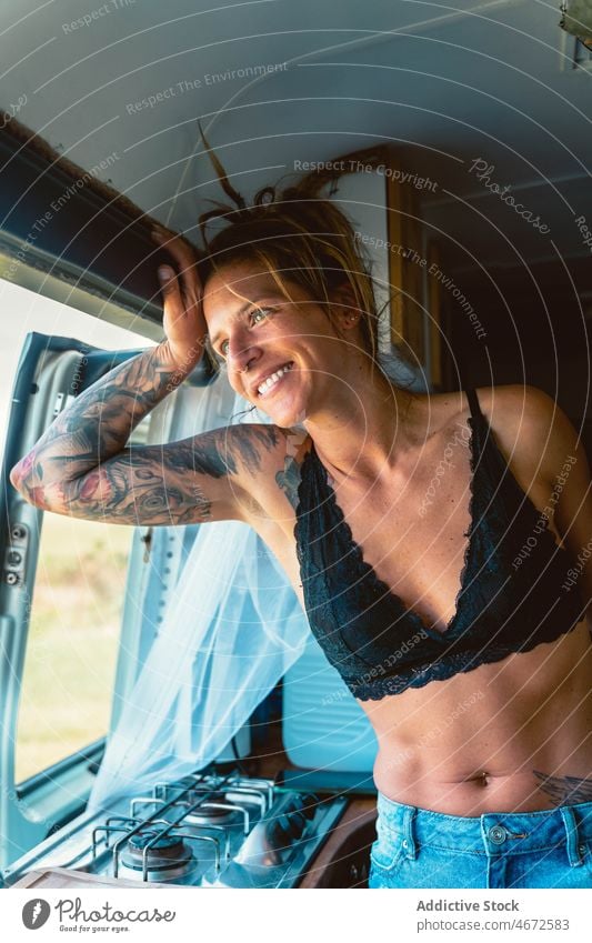 Lächelnde Frau im BH schaut auf das Fenster im Wohnmobil Reisender Glück bewundern reisen Ausflug rv genießen Kleintransporter Wohnwagen Anhänger positiv