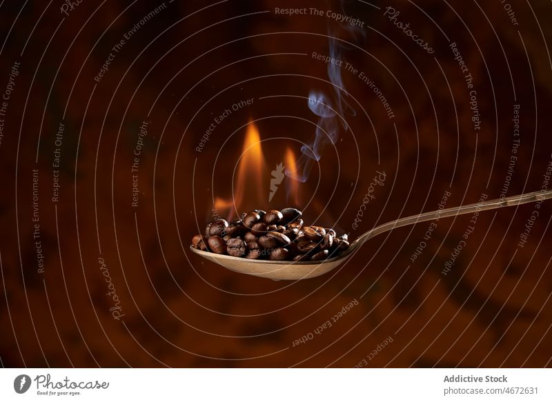 Löffel voll mit erhitzten Kaffeebohnen auf braunem Hintergrund Bohne Braten Haufen Feuer Aroma Rauch Bestandteil Energie natürlich Koffein Korn Produkt lecker