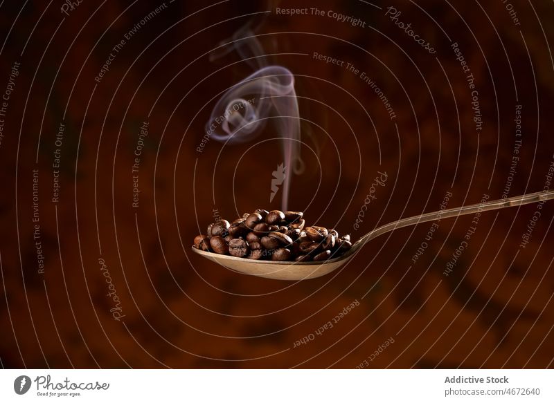 Löffel voll mit erhitzten Kaffeebohnen auf braunem Hintergrund Bohne Braten Haufen Aroma Rauch Bestandteil Energie natürlich Koffein Korn Produkt lecker