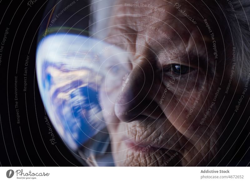 Ältere Frau im Raumanzug schaut auf die Erde Globus Denken Zukunft besinnlich Planet Anzug ernst nachdenklich Fokus Senior Konzentration Konzept Suche