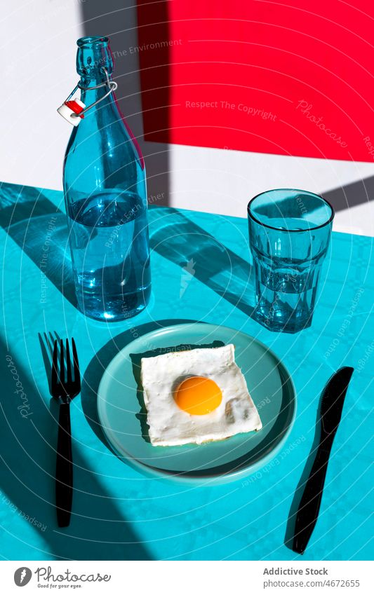 Teller mit Spiegelei und Geschirr und Flasche mit Glas Ernährung lecker Tisch Gabel geschmackvoll Messer gebraten Ei Wasser Lebensmittel dienen Mahlzeit frisch