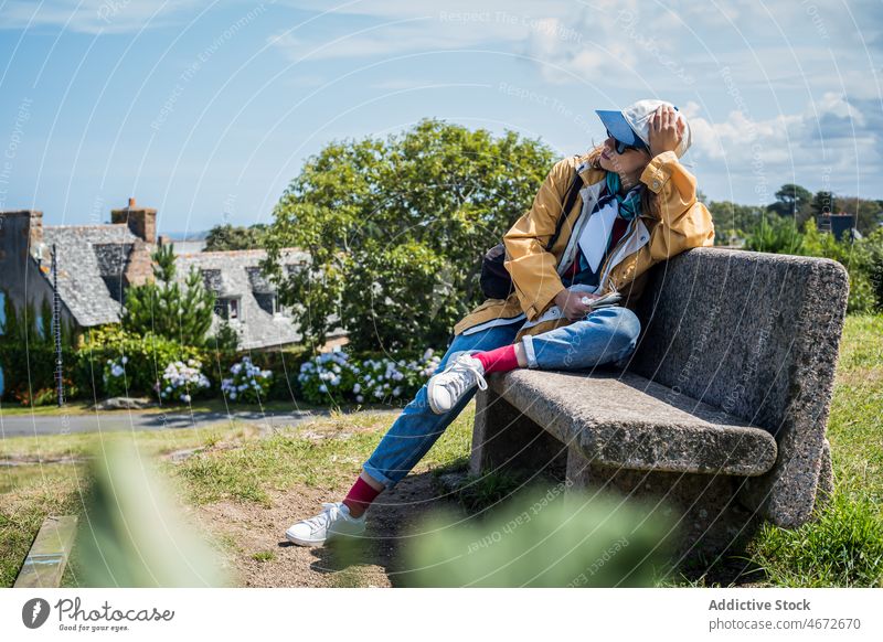 Frau auf Bank in der Stadt Gebäude Vorstadt Haus reisen Reisender Viertel Straße ruhen wohnbedingt Pflanze Stein Kopfbedeckung Urlaub lässig Frankreich Europa