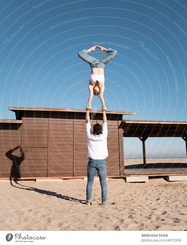 Anonymes Paar macht Handstand am Strand Sport von Hand zu Hand Artist akrobatisch Übung Stauanlage üben Training sportlich beweglich passen Frau Mann