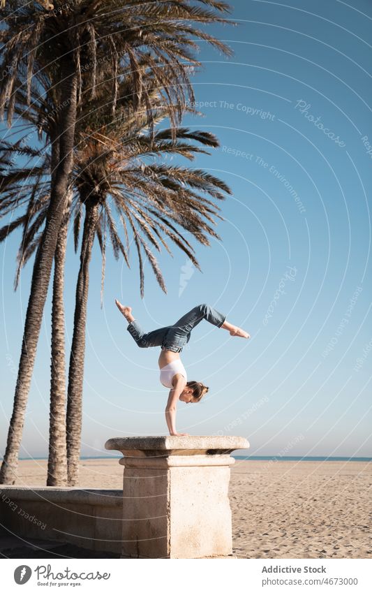 Frau macht Handstand auf einer Böschung Kopfstand Sport Stunt Artist akrobatisch Stauanlage üben Hafengebiet Gleichgewicht passen Figur Küste Strand Freizeit