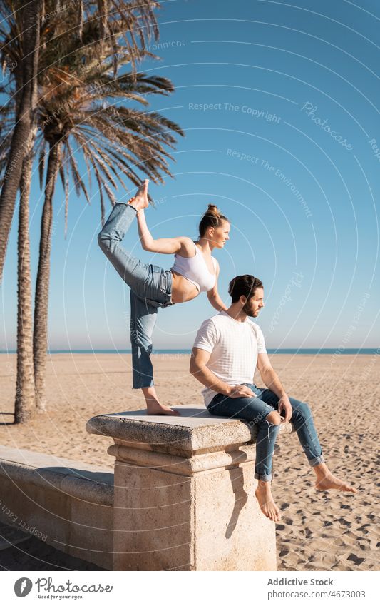 Frau in Natarajasana-Haltung neben Mann am Ufer Paar Herr des Tanzes Asana Übung Stauanlage üben Hafengebiet Gesunder Lebensstil Yoga beweglich passen Figur