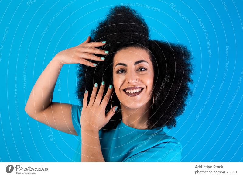 Glückliche hispanische Frau mit Afrofrisur Afro-Look Frisur Lächeln Mode Stil trendy Vorschein Freude Stilrichtung feminin lässig froh attraktiv charmant