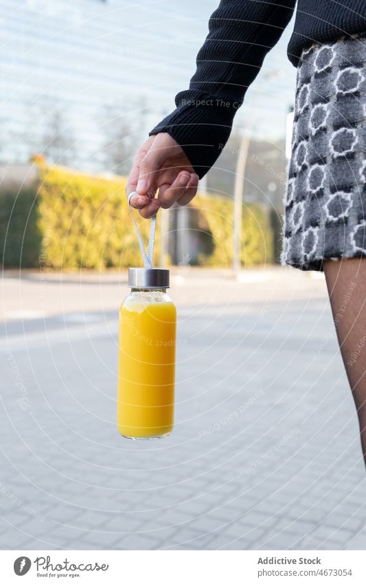 Unbekannte Frau mit Saftflasche Flasche Erfrischung Getränk Straße trinken Großstadt Laufsteg orange Glas Dame Stadt Vitamin Rock Entzug Bürgersteig lecker