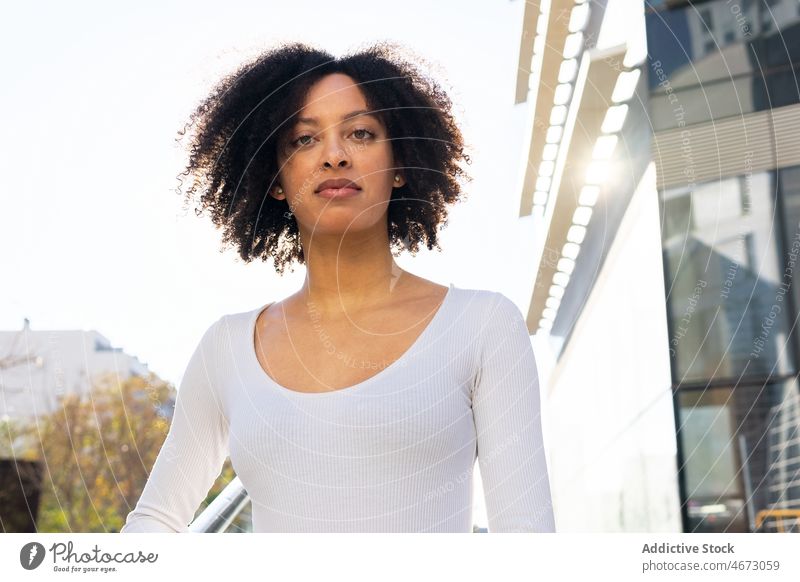 Ernste schwarze Frau auf einer Treppe in der Stadt Straße Stil Gebäude urban Großstadt feminin Vorschein trendy Outfit modern elegant Mode selbstbewusst Reling
