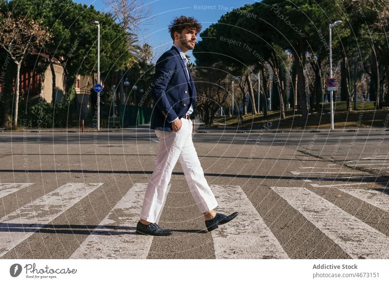 Stilvoller hispanischer Mann beim Überqueren der Straße Zebrastreifen Fußgänger Großstadt elegant urban Vorschein männlich selbstbewusst gutaussehend Vollbart