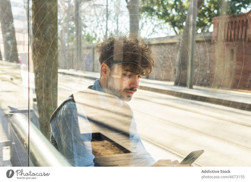 Durch das Glas eines hispanischen Mannes, der in der Stadt auf seinem Smartphone surft Textnachricht Browsen online Stil Großstadt Straße Talkrunde Vorschein