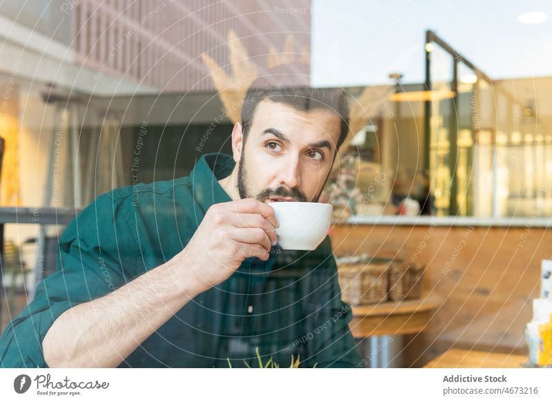 Mann trinkt Kaffee im Cafe trinken Heißgetränk Kuchen Dessert Pause Mittagessen Café durch Fenster Unternehmer Kantine nachdenklich Tisch Tasse besinnlich