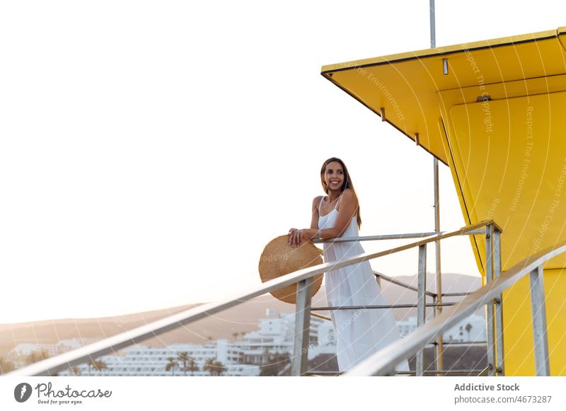 Glückliche Frau ruht sich in der Nähe des Rettungsschwimmerturms aus Sommer Seeküste Reisender Strand ruhen Feiertag genießen jung Urlaub reisen heiter
