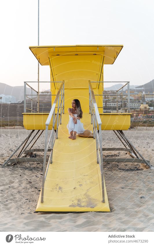 Glückliche Frau ruht sich in der Nähe des Rettungsschwimmerturms aus Sommer Seeküste Reisender Strand ruhen Feiertag genießen jung Urlaub reisen heiter