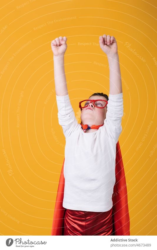 Kind im Superhelden-Outfit hebt die Arme hoch Junge Flug Fliege die Faust ballen Tracht Porträt Atelier Arme hochgezogen Kraft Mut Held selbstbewusst Kap stark